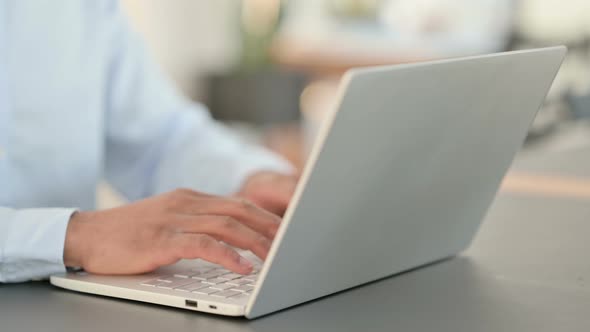 African Man Hands Typing on Laptop Close Up