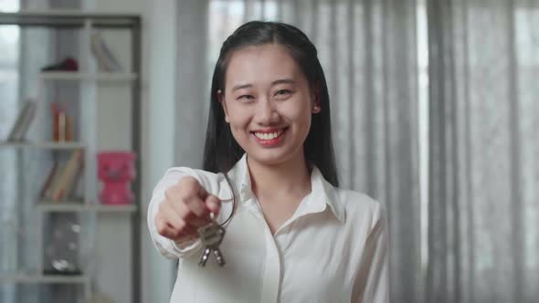 Close Up Of Asian Woman Smiling And Showing Keys To Camera In The New House