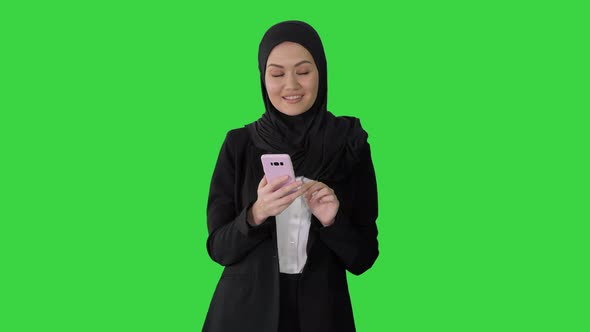 Smiling Arab Woman Using Smart Phone on a Green Screen, Chroma Key