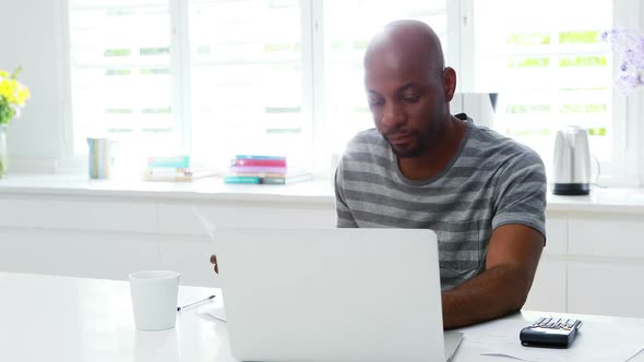 Man using laptop in kitchen 4k