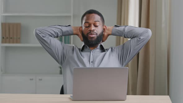 Focused Young Bearded Male Black Businessman Office Employee Typing on Laptop Put Hands Behind Head