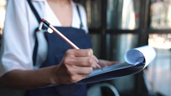 Female administrator writes down a list of goods