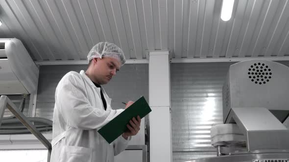 Cheese Production  Man Worker Mixing Fresh Pieces Of A Soft Cheese In The Vat