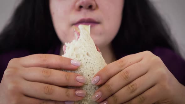 Extreme Close-up of Obese Caucasian Brunette Woman Chewing Sandwich. Young Fat Girl Eating Unhealthy