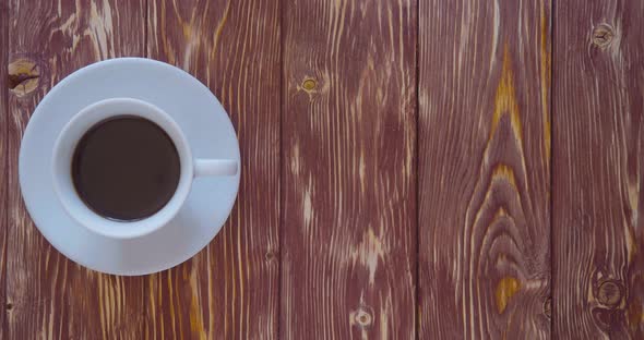 Vertical Video  Male Hands Put a Cup of Coffee a Spoon a Pen and a Notepad on a Wooden Vintage Table