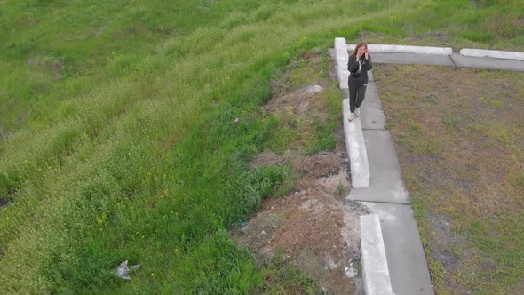 Woman Walking With Phone Aerial