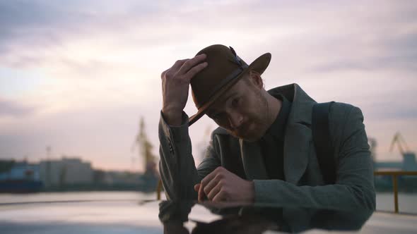 Portrait of Young Redhead Stylish Handsome Hipster on Sea Port Background During Sunset