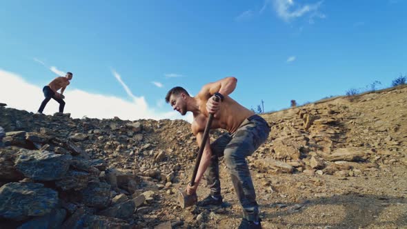 Strength sportsmen training on rocky background