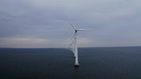 Scenery of Calm Sea Waters and Windmills Rotating in Unison