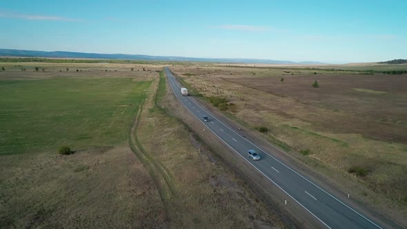 Aerial View of an Intercity Asphalt Road in Rural Area Road Between Fields with Rare Trees