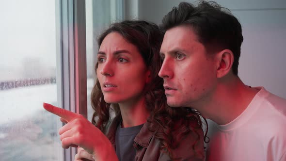 Couple Looks at Crime Scene Though Window with Police Lights
