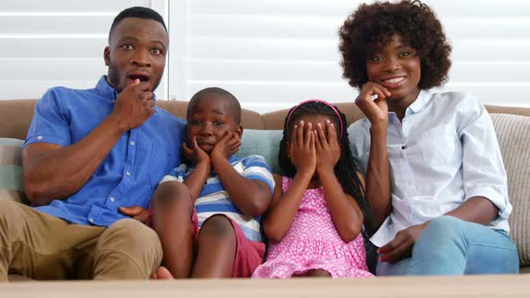 Family sitting on sofa and watching television