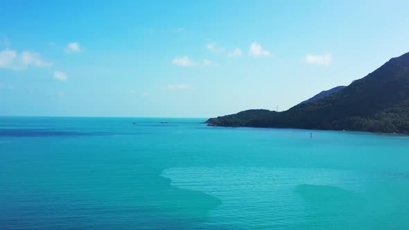 Aerial drone shot nature of tropical shore beach lifestyle by blue sea and white sandy background of