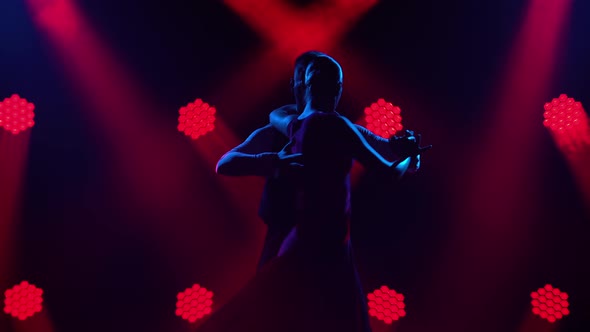 Graceful Argentine Tango Among Smoke and Bright Red Neon Lights in a Dark Studio