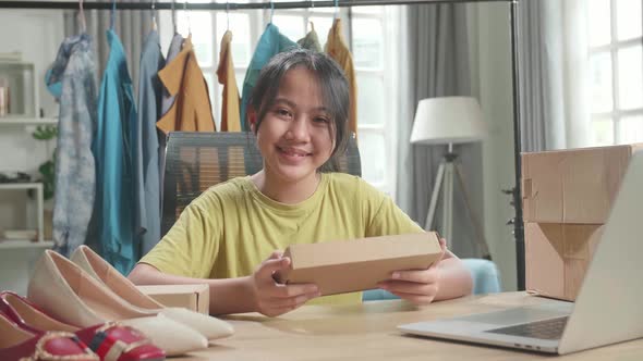 Asian Young Girl Online Seller With Package Look At Camera And Smile While Selling Clothes At Home