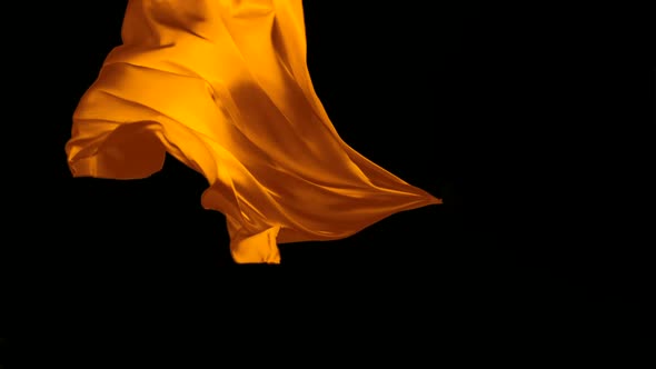 Orange fabric flowing on black background, Slow Motion