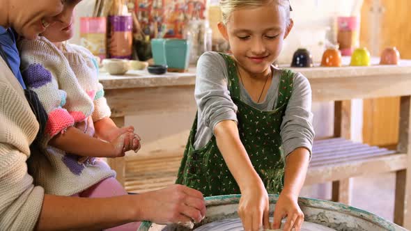 Mother assisting her daughter in making a bowl