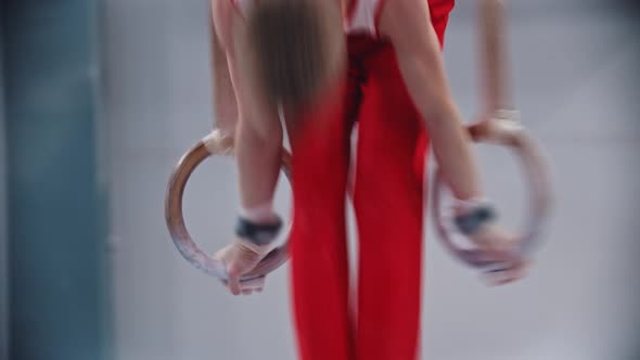 A Little Boy Doing Gymnastic Exercises on the Rings