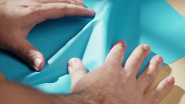 Hands Crumpling Blue Paper Closeup