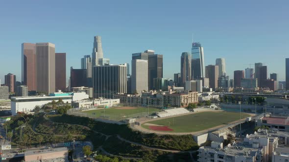 Empty Sports Stadium By City Skyline Aerial Dolly in Revealing Skyscrapers of Los Angeles California