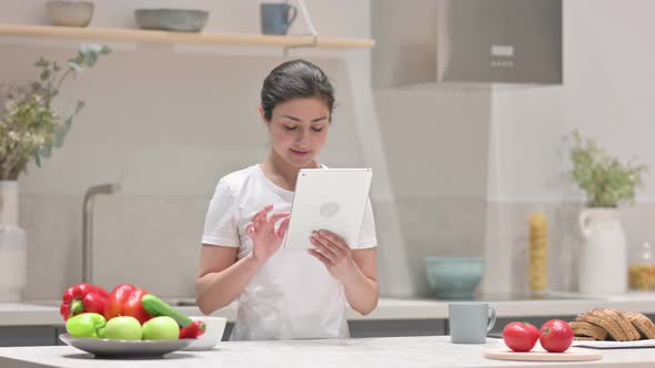 Young Indian Woman Using Tablet in Kitchen