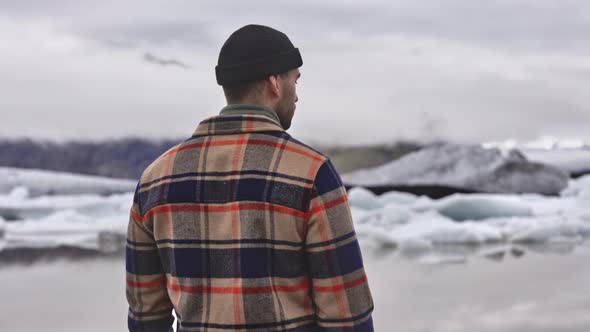 Clear Skies Frozen Lake and Melting Glacier with Male Tourist in Foreground