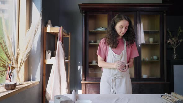 Female Artist is Working in Her Pottery Workshop Sculpting Clay