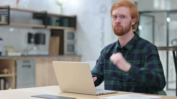 Young Beard Redhead Man with Laptop Showing Thumbs Down