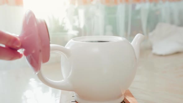 Close-up of a white porcelain teapot standing on a on the table