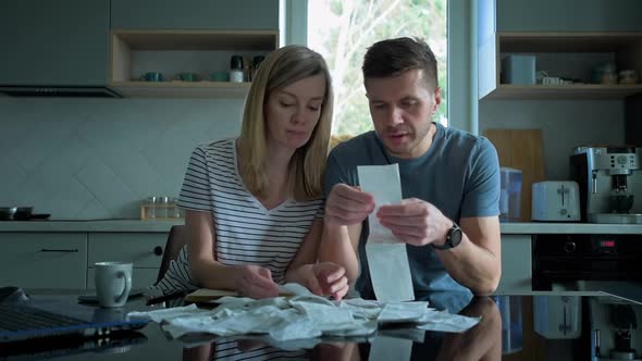 Man and Woman Looking at Payment Bills in the Kitchen