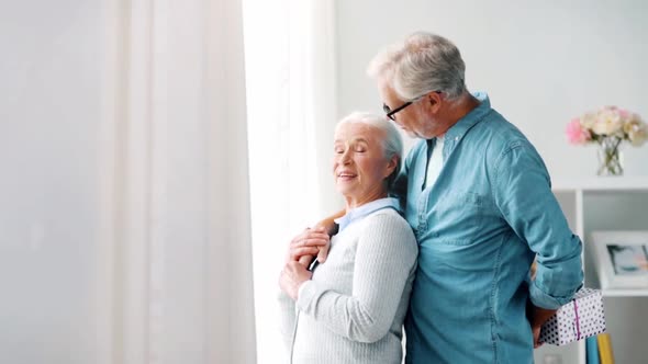 Happy Senior Couple with Birthday Gift at Home 