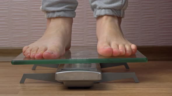 Women's Feet Stand on the Scales and Check Their Kilograms Front View