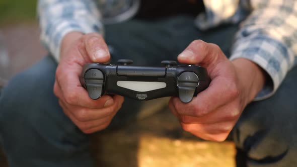 Young Man Holds a Joystick and Plays Games