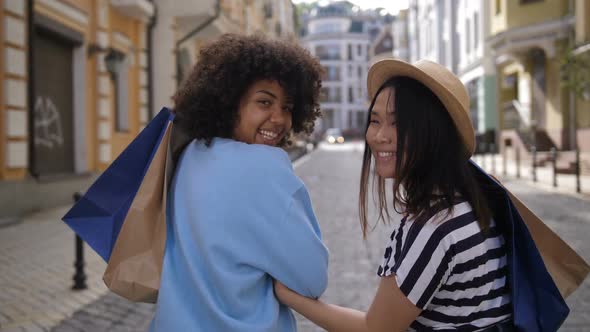 Mixed Race and Asian Shopaholic Women Smiling