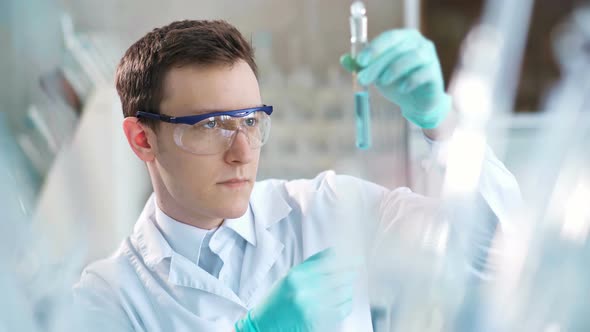 Young Scientist Checking Test Tubes in the Lab alt