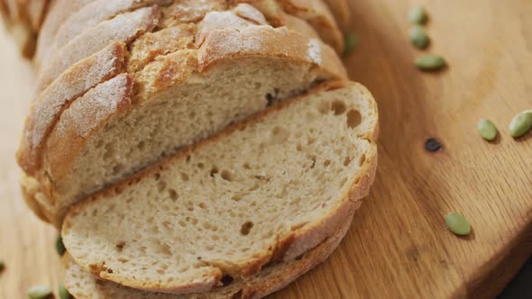 Video of bread on chopping wooden board on wooden worktop