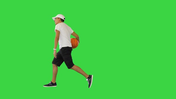 Young Casual Man Bouncing Basketball Ball on a Green Screen Chroma Key