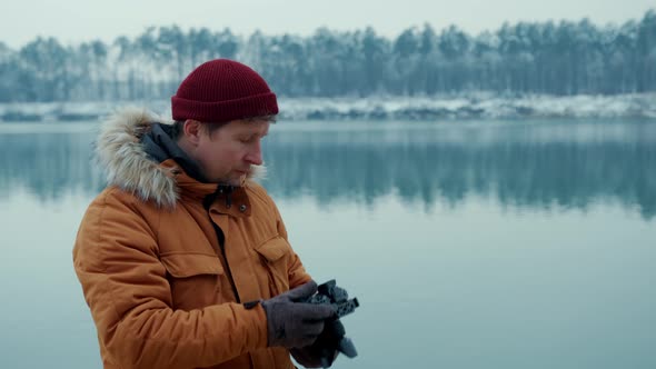 Portrait Man Photographer Takes Pictures of a Lake in the Winter Forest