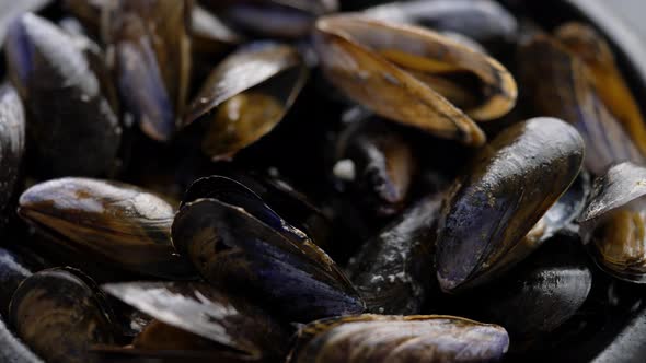 Close Up Shot of Fresh and Raw Sea Mussels in Black Ceramic Bowl Placed on Dark
