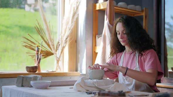 Adult Woman is Making Ceramic Cup in Pottery Workshop