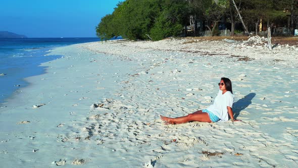 Pretty beauty models relaxing having fun on the beach on sunny blue and white sand background 4K