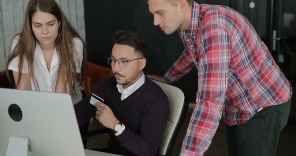 Man Makes Purchases Over the Internet on a Computer and Pays By Credit Card at the Office