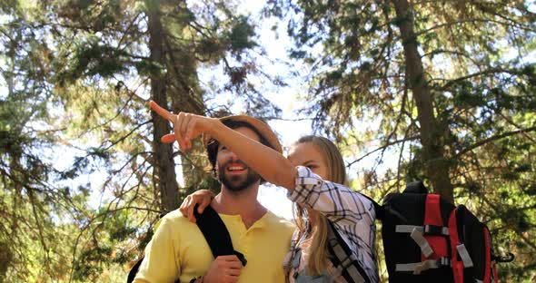 Hiker couple standing and pointing away in forest