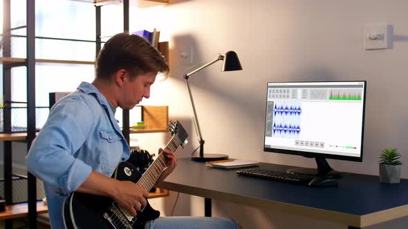 Man Playing Guitar and Recording Music at Home