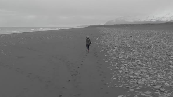 Wide Aerial Shot of a Woman Running in a Vast Landscape.