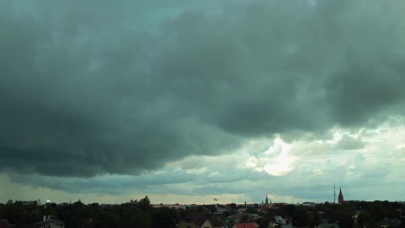 Time lapse of dark dramatic fasting storm clouds over the city, medium shot