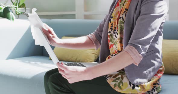 Mid section of woman wiping her laptop with a tissue