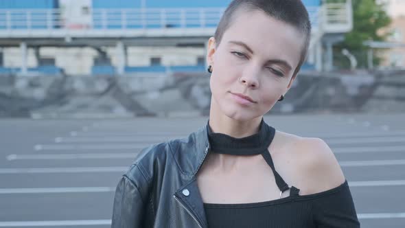 Portrait of Smiling Young Woman with Short Hair in Industrial City Background at Sunset