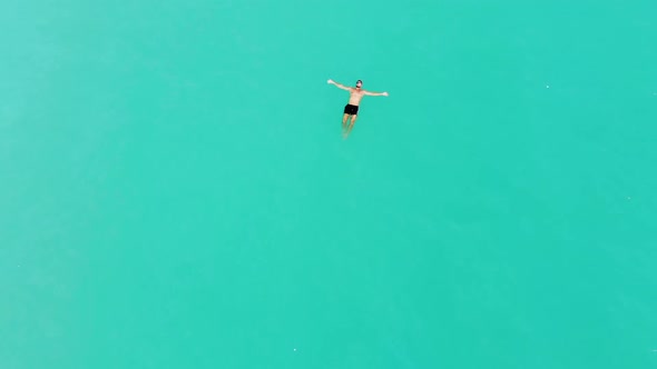 A Young Male Model Swimming Alone In the Turquoise Caribbean Sea In Slow-Motion