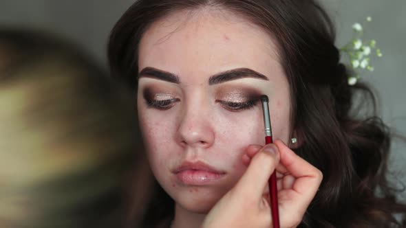 Makeup Artist Paints the Eyelids of a Girl Model